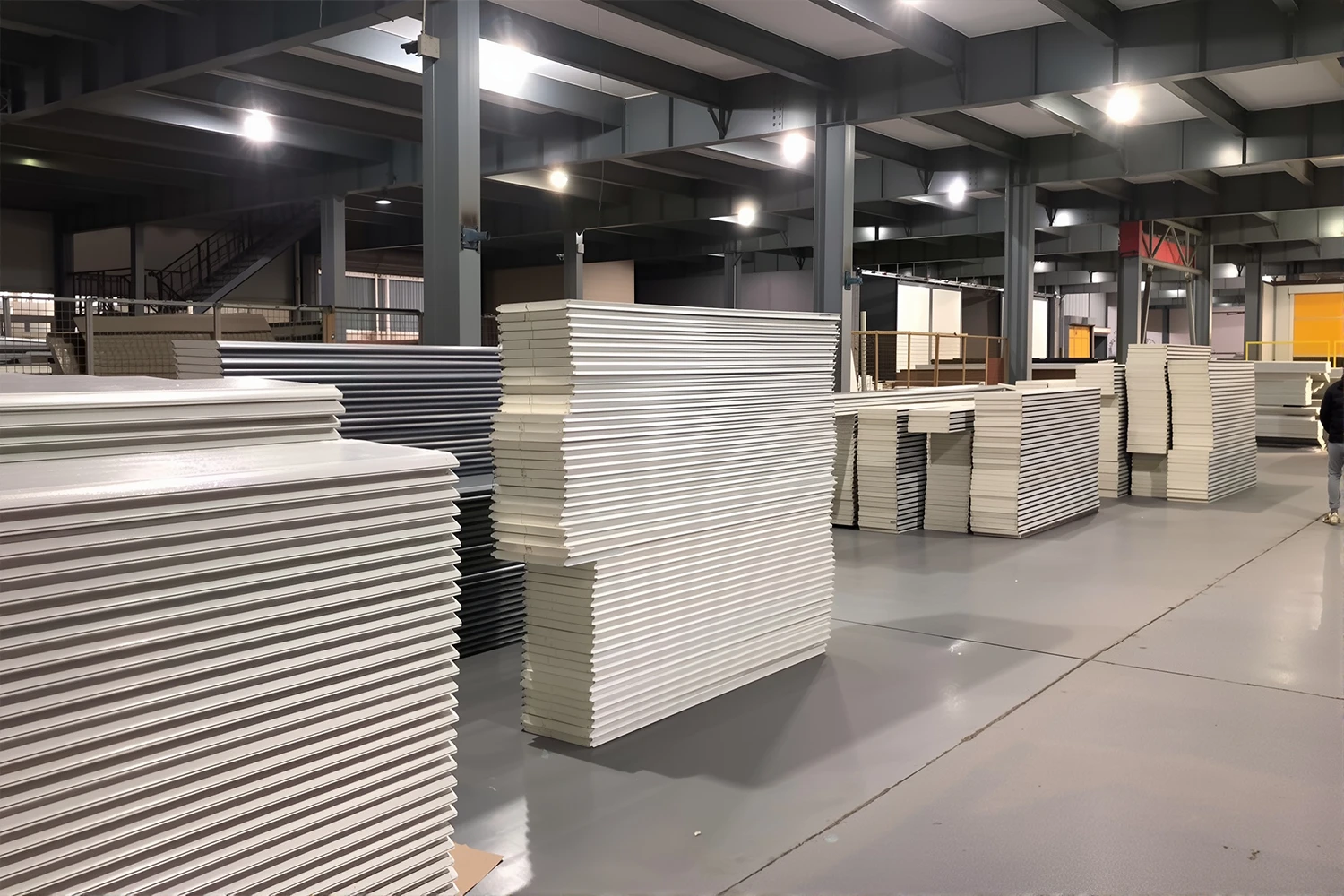 Stacks of heavy-duty commercial garage door panels and insulated PU sandwich panels ready for wholesale distribution at the ABX manufacturing facility.